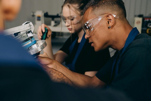 man-and-woman-in-goggles-working-at-workshop